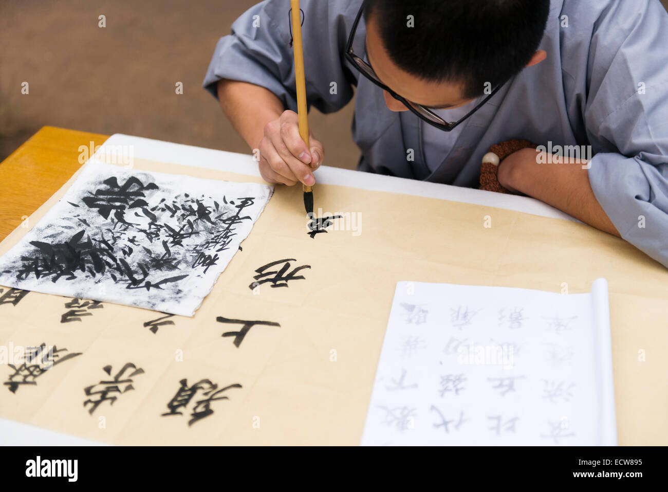 Lizenz erhältlich unter MaximImages.com - Student of a Shaolin Martial Arts School praktiziert chinesische Kalligraphie in Dengfeng, Henan, China 2014 Stockfoto