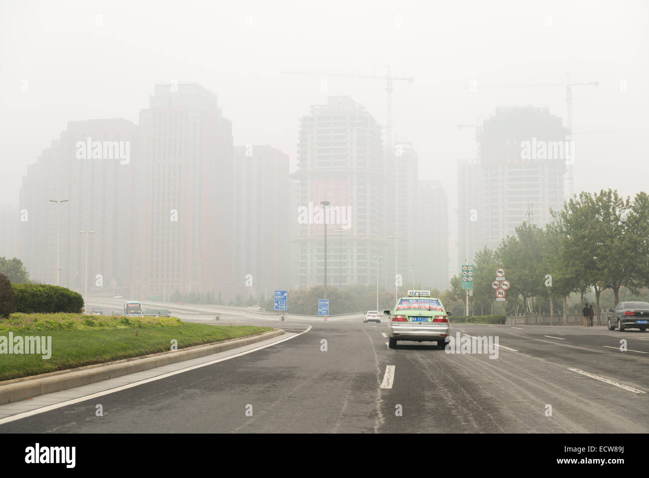 Entwicklung der Skyline der Stadt bedeckt Smog, Blick von einer Autobahn in ZhengZhou, Henan, China 2014 Stockfoto