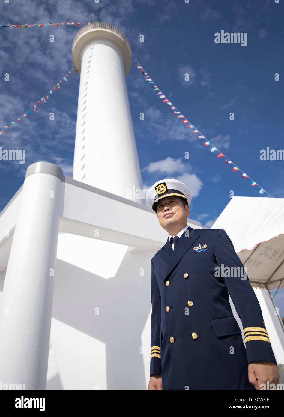 Japanische Self Defense Force Küstenwache Offizier steht vor dem Kap Zanpa Leuchtturm, Yomitan, Okinawa, Japan Stockfoto