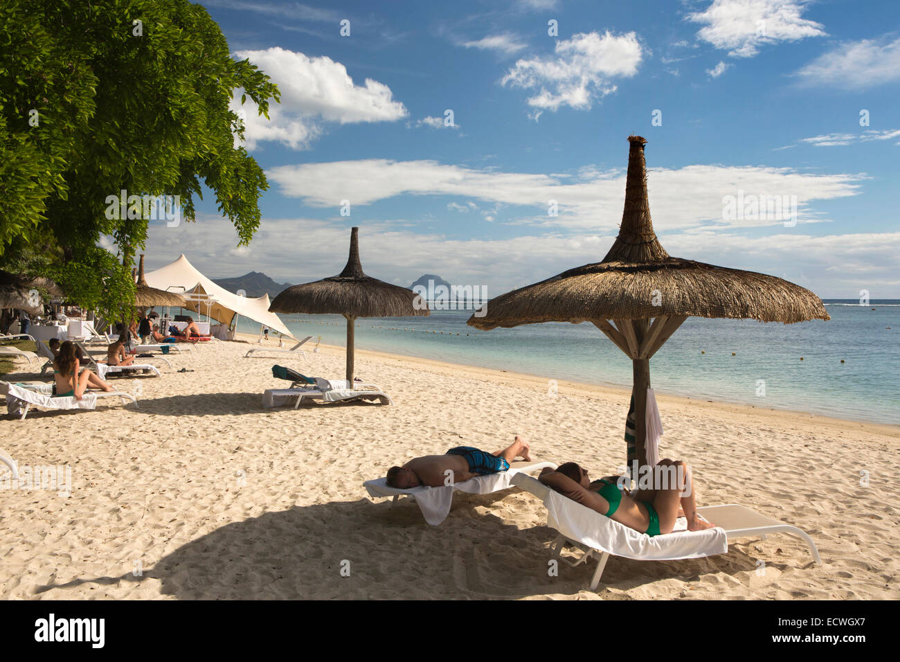 Mauritius, Flic En Flac, öffentlichen Strand, Besucher zum Sonnenbaden und auf Liegestühlen im Schatten der Sonnenschirm Stockfoto