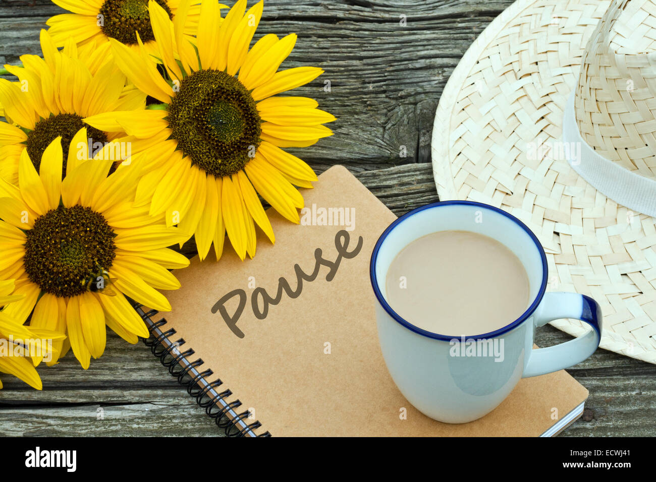 Sonnenblumen- und Kaffeebecher und Strohhut Stockfoto
