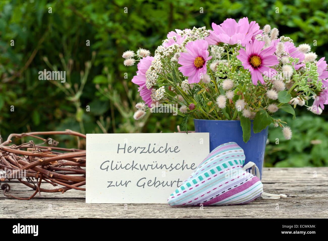 Deutsche Grußkarte mit pinkfarbenen Sommerblumen und Text: Gratulation zur Geburt Stockfoto