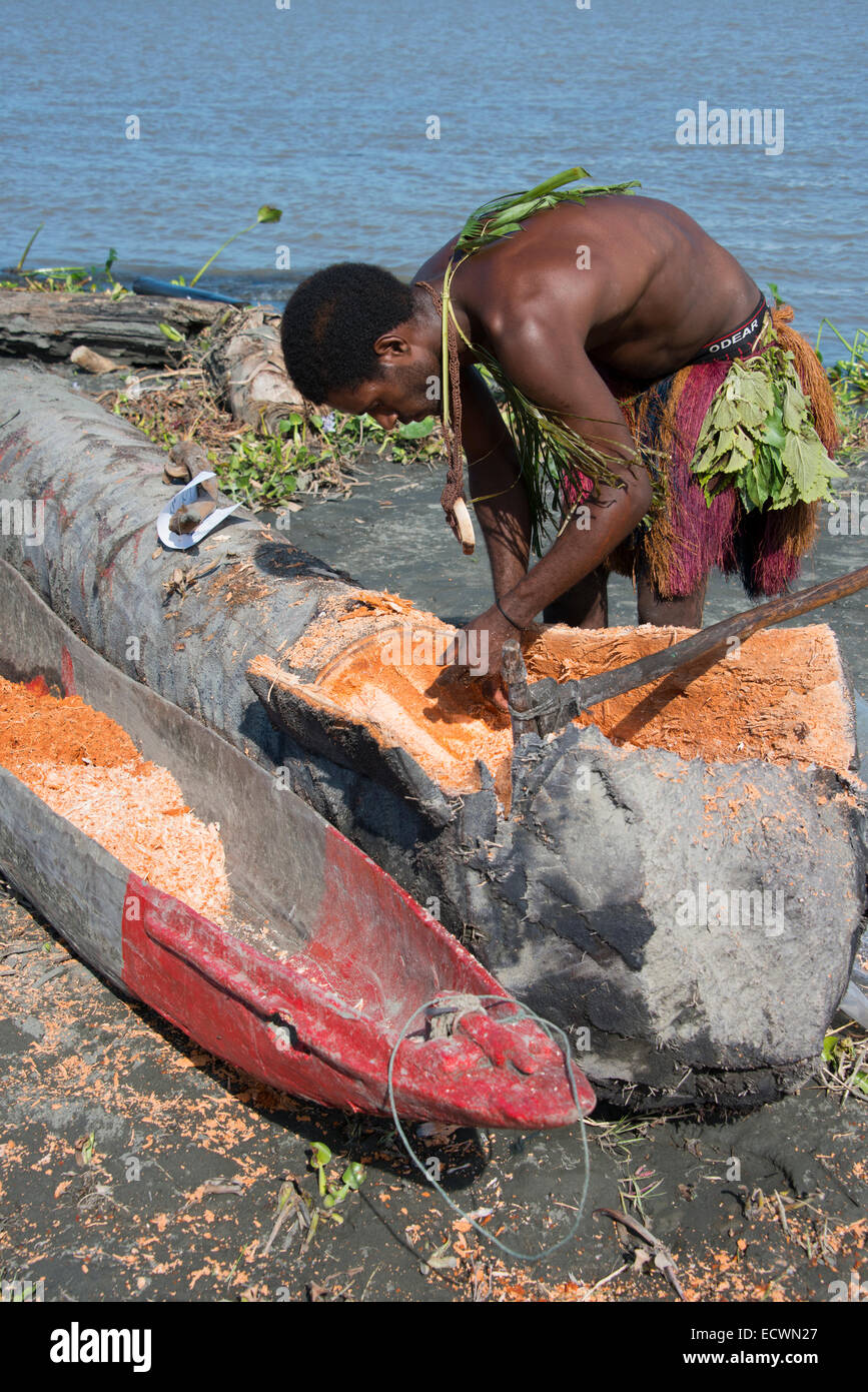 Melanesien, Papua-Neu-Guinea, Sepik River Gebiet, Dorf von Kopar. Lokale Mann entlang des Flussufers Sagopalme Holzhacken. Stockfoto