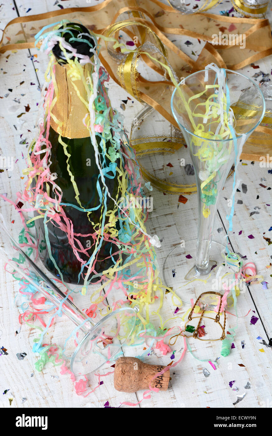 Hohen Winkel Schuss eine Flasche Champagner, Luftschlangen und Konfetti nach einer New Years Eve Party. Hochformat mit geringe Schärfentiefe Stockfoto