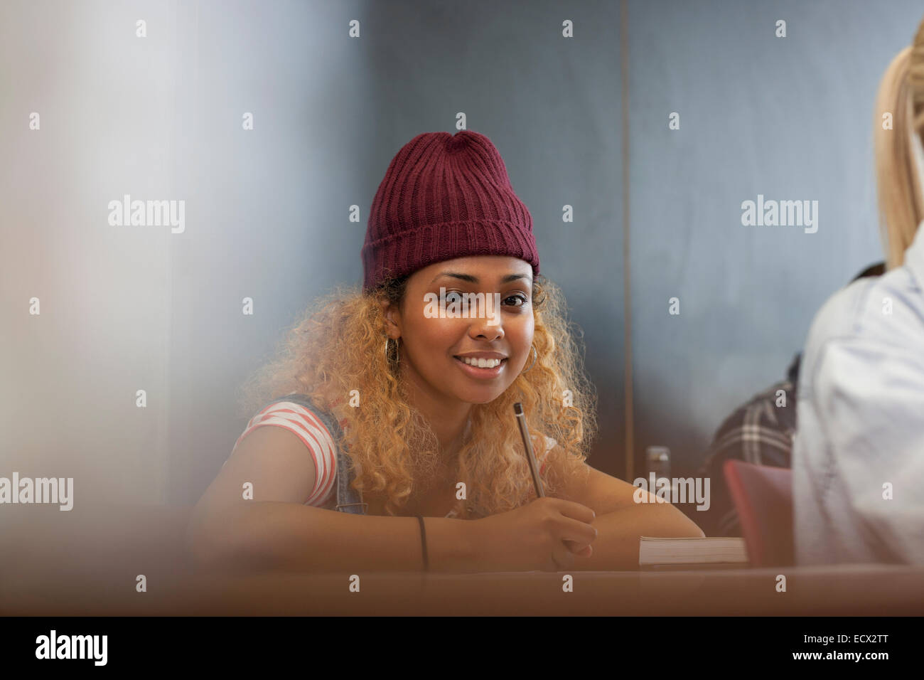 Porträt des Lächelns weibliche Studentin aufschreiben von Notizen im Klassenzimmer Stockfoto