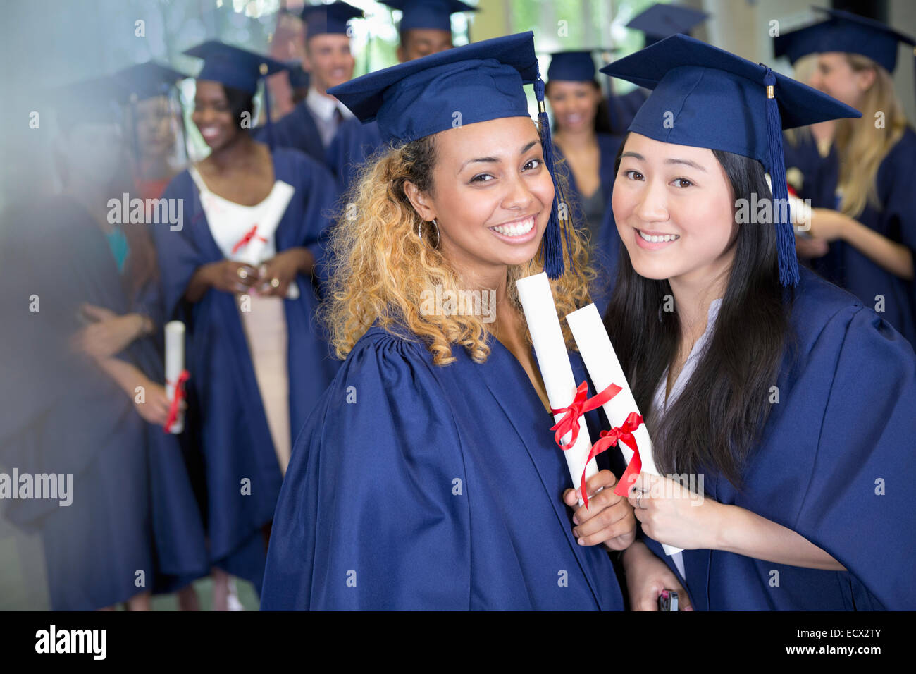 Porträt des Lächelns Studenten mit Diplomen stehend im Flur Stockfoto