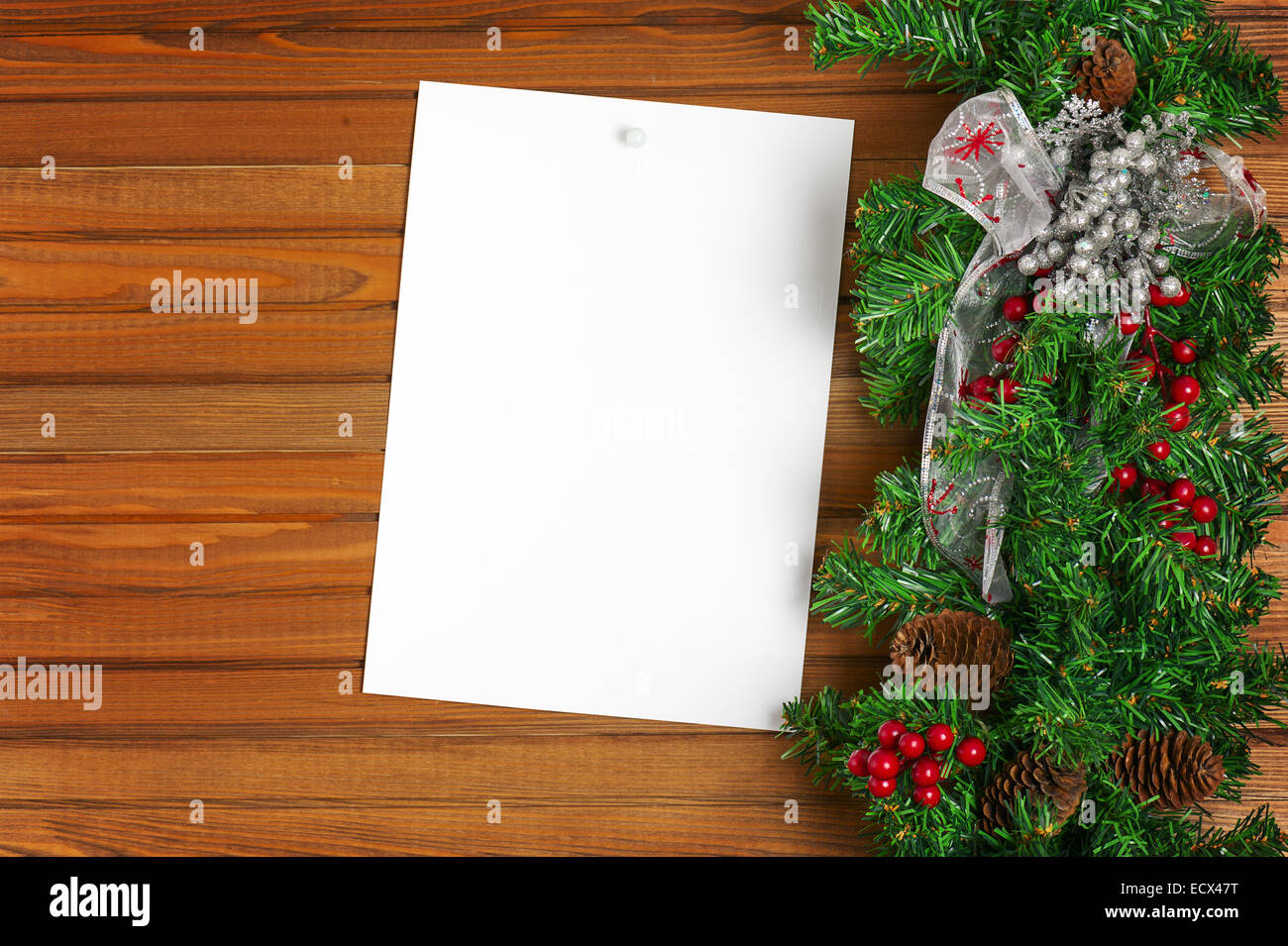 Girlanden Sie mit Weihnachten Ornamente, Tannenzapfen und Blatt Papier auf Holz Hintergrund. Stockfoto