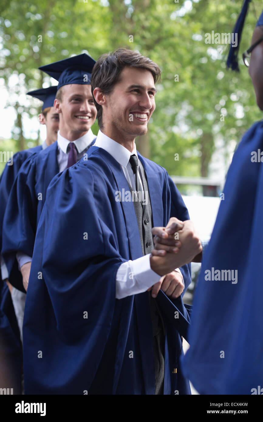 Studenten der Universität gratulieren einander nach Abschlussfeier Stockfoto
