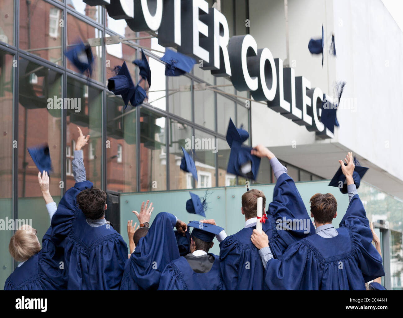 Gruppe von Studenten werfen Graduierung Hüte außerhalb der Hochschule Stockfoto