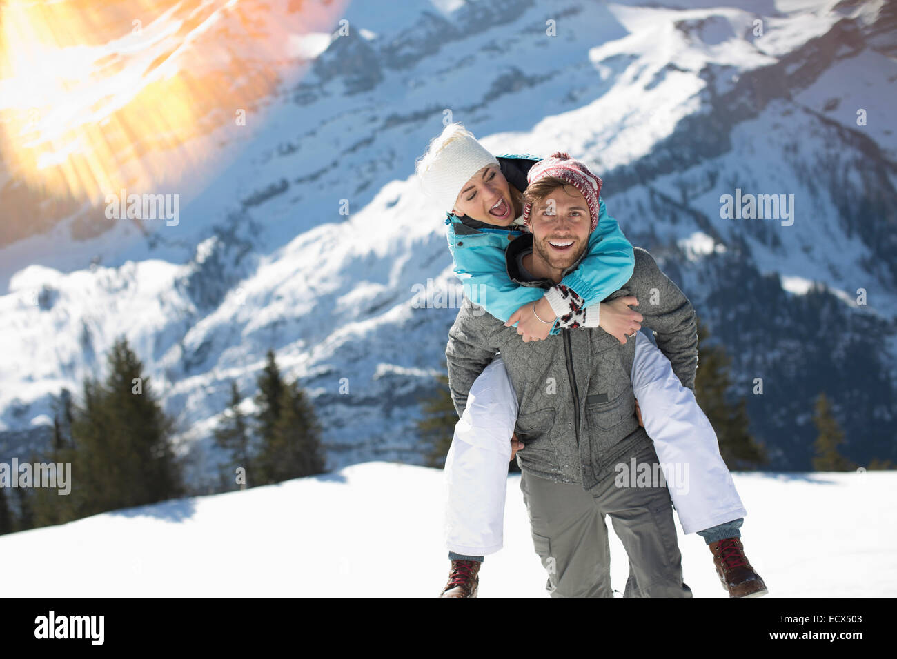 Paar Huckepack im Schnee Stockfoto