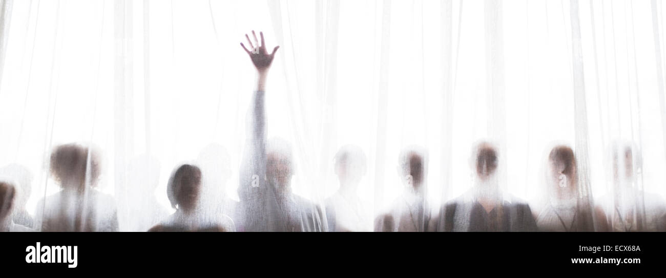 Silhouette des Menschen hinter transparenter Vorhang, eine Person, die Hand steigt Stockfoto