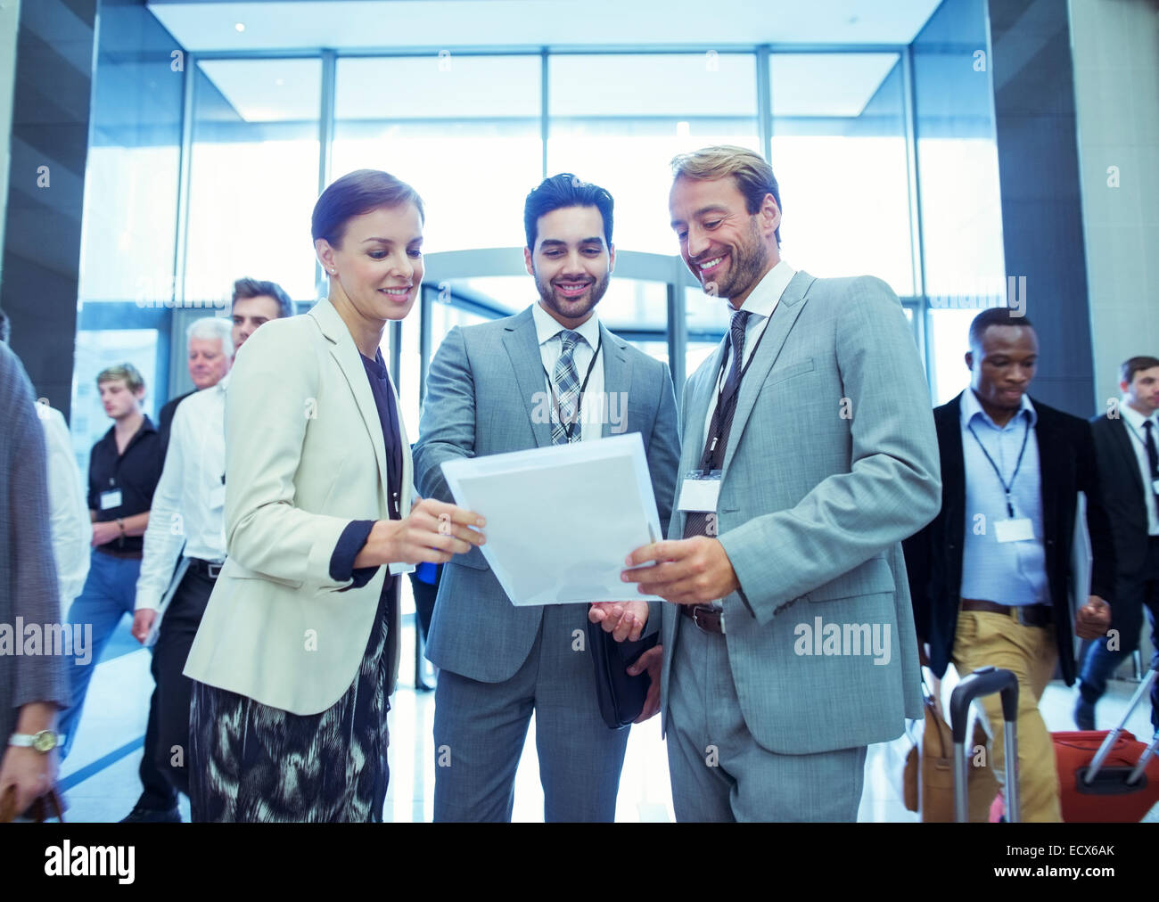 Porträt der Geschäftsfrau und zwei Geschäftsleute stehen in der Lobby des Konferenzzentrum Stockfoto