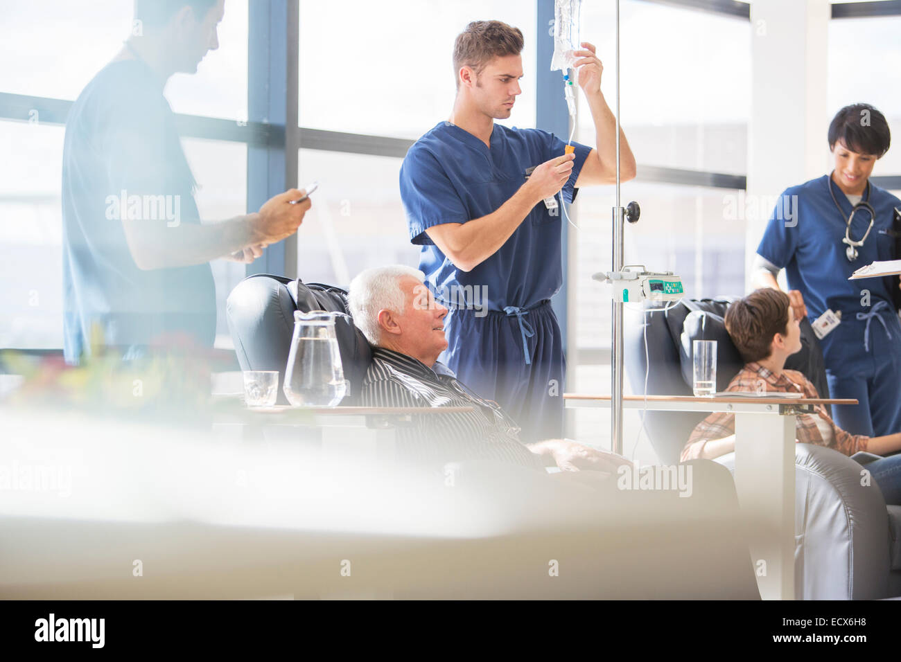 Ärzte, die Patienten, die intravenöse Infusion im Krankenhaus besuchen Stockfoto
