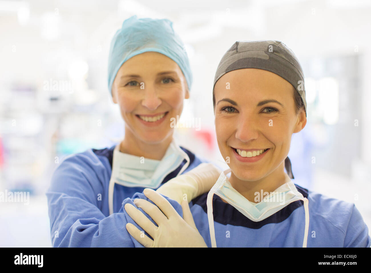 Porträt von zwei weiblich lächelnd Ärzte tragen chirurgische Kappen im Operationssaal Stockfoto