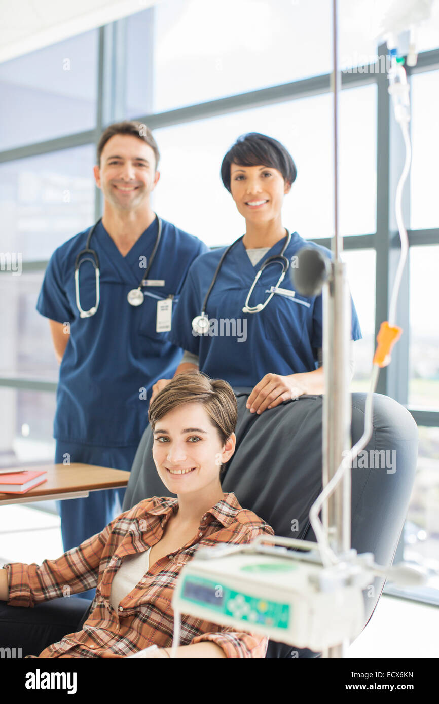 Ärzte, die Patienten in medizinischer Behandlung in Ambulanz steht lächelnd Stockfoto
