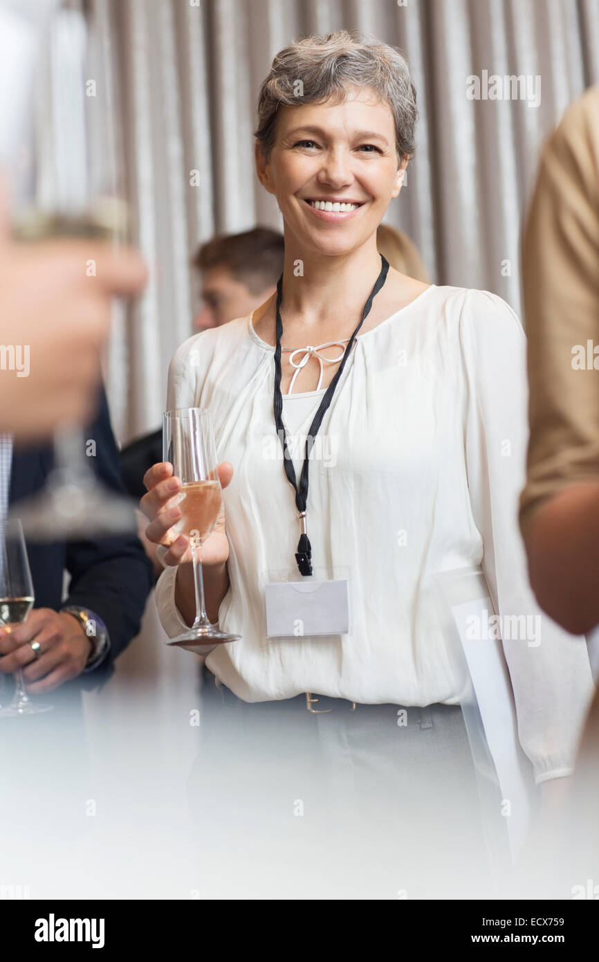 Porträt des Lächelns Reife Geschäftsfrau Holding Champagne flute Stockfoto