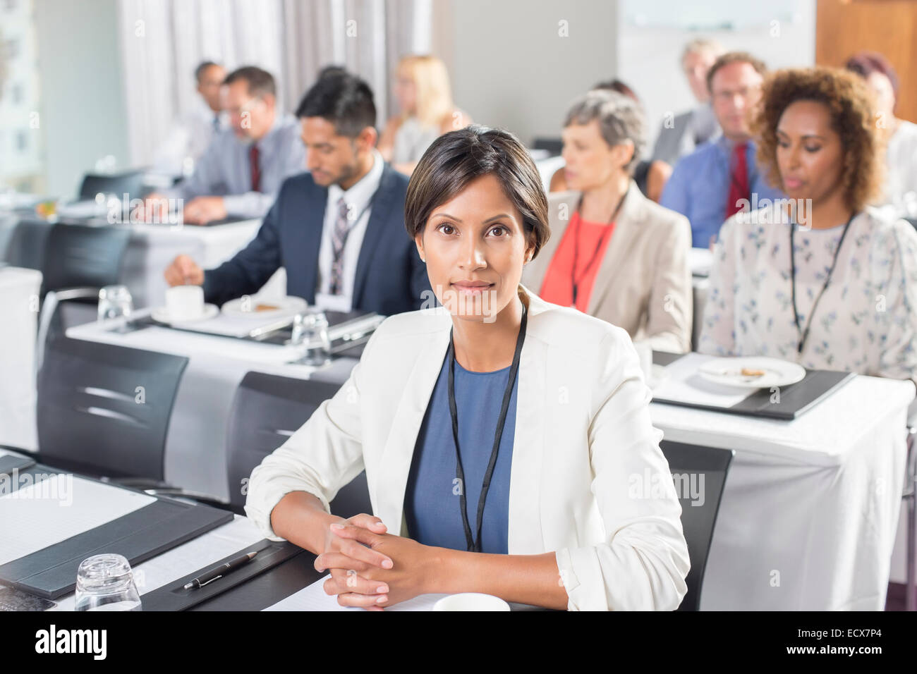 Porträt der Frau mit Gruppe von Geschäftsleuten im Hintergrund, die Teilnahme an seminar Stockfoto