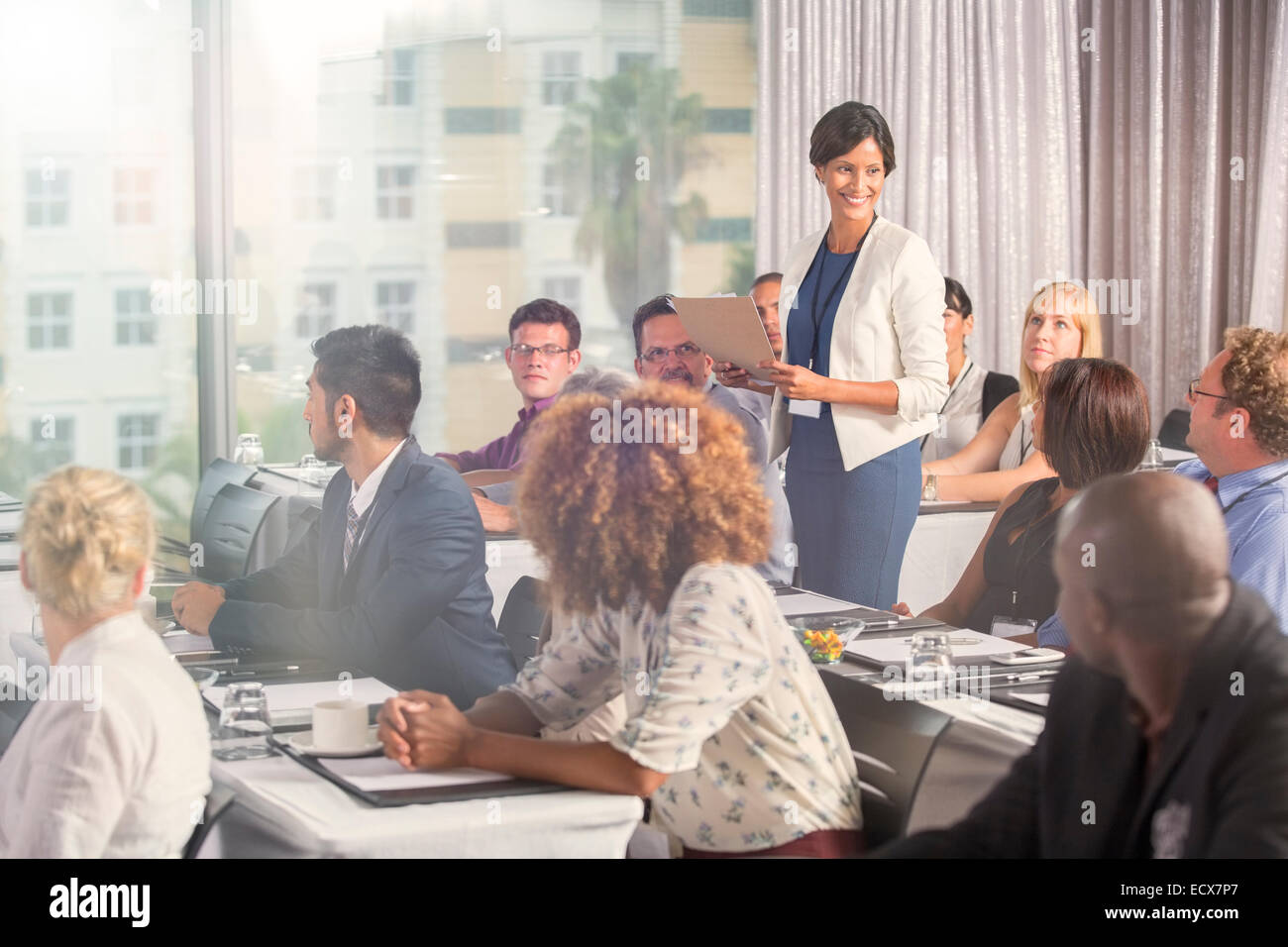 Gruppe von Menschen sitzen am Schreibtisch und Lautsprecher hören Stockfoto