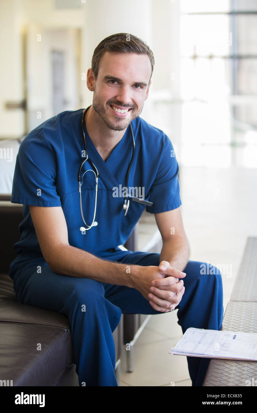 Porträt von männlichen Arzt auf Sofa im Krankenhaus Stockfoto