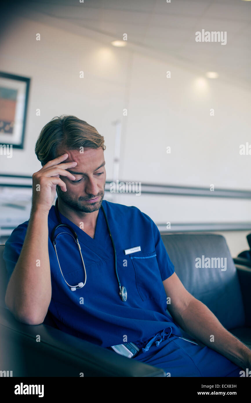 Männlichen Arzt auf Sofa im Krankenhaus Stockfoto