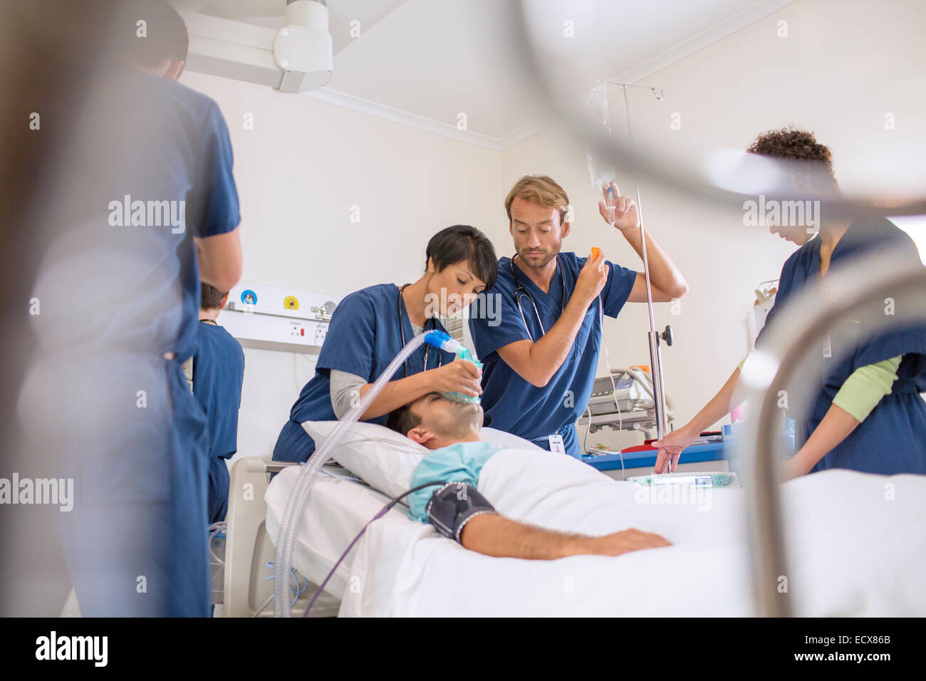 Arzt Holding Sauerstoffmaske über Patienten, männlichen Arzt anpassen Tropf Stockfoto