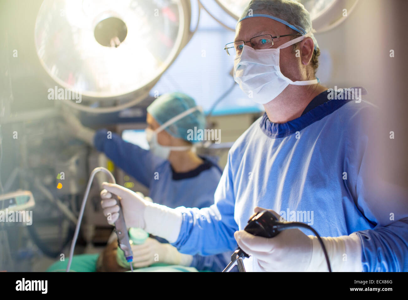 Männliche Chirurgen halten Laparoskopie Ausrüstung während der Operation im Operationssaal Stockfoto