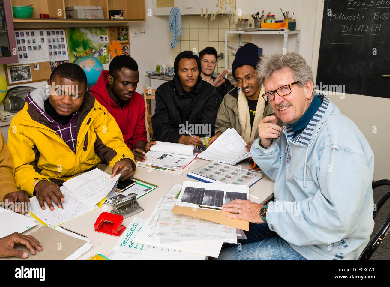 Ein pensionierter Sozialarbeiter arbeitet als freiwilliger jetzt (rechts), eine Lektion in deutscher Sprache, meist afrikanischen Flüchtlinge gibt. Stockfoto