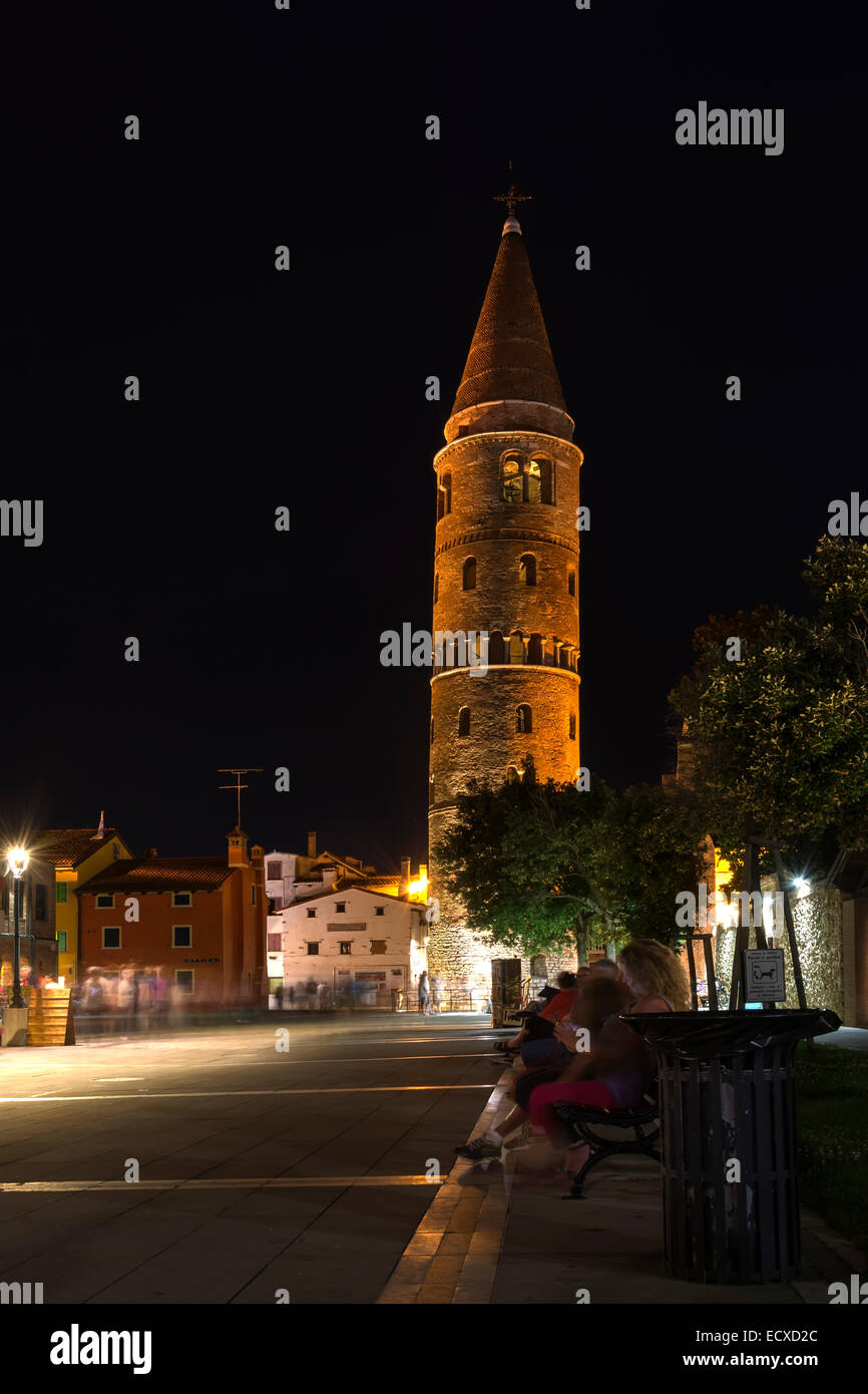 Caorle, Italien Juni 2014 - Nächtlicher Blick auf den schiefen Turm der romanischen Kathedrale mit Besuchern während der Sommerferien Juni Stockfoto