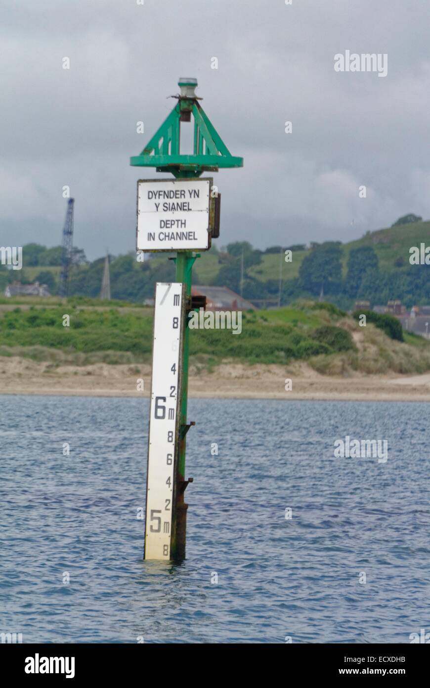 Fahrwassermarkierung und Tiefe Guage am Eingang von Pwllheli Hafen und Marine mit Wellenbrecher im Hintergrund Stockfoto