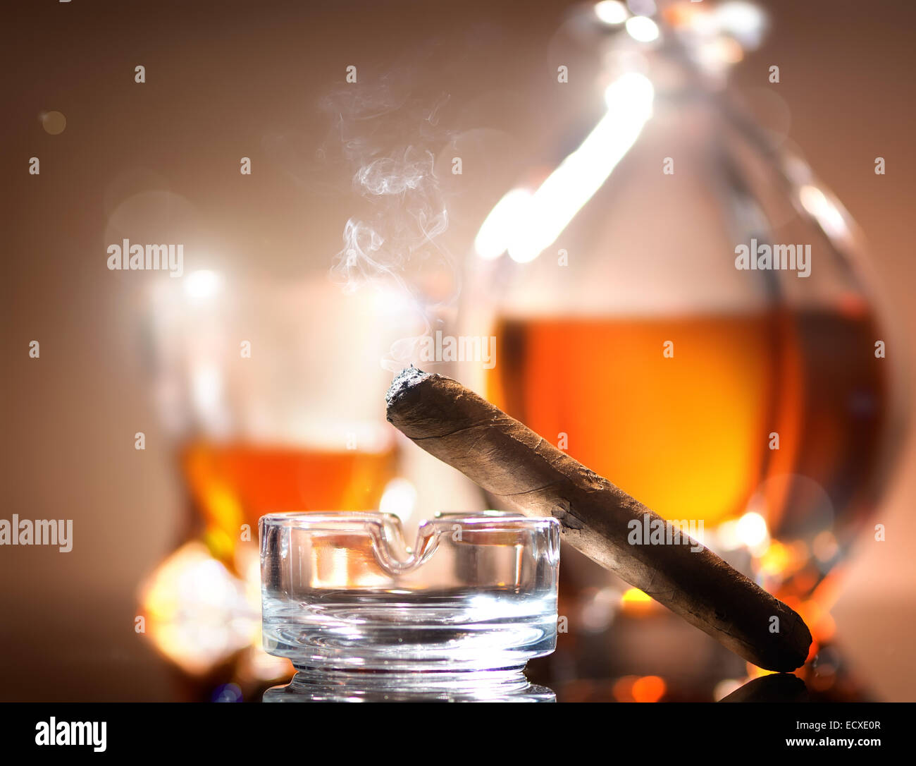 Zigarre auf Aschenbecher auf einem Hintergrund von Whisky Stockfoto