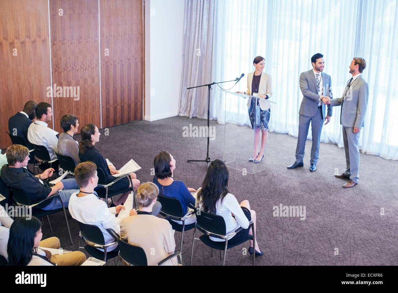 Öffentliche Redner Händeschütteln auf der Bühne während der Konferenz Stockfoto