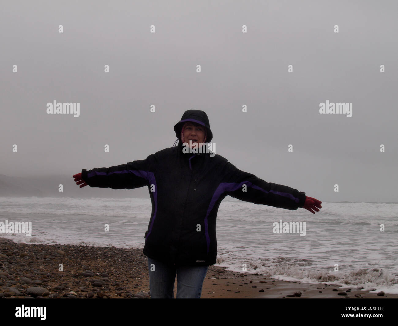 Frau spielt am Strand auf eines grauen, nebligen Winters Tag, Widemouth Bay, Cornwall, UK Stockfoto