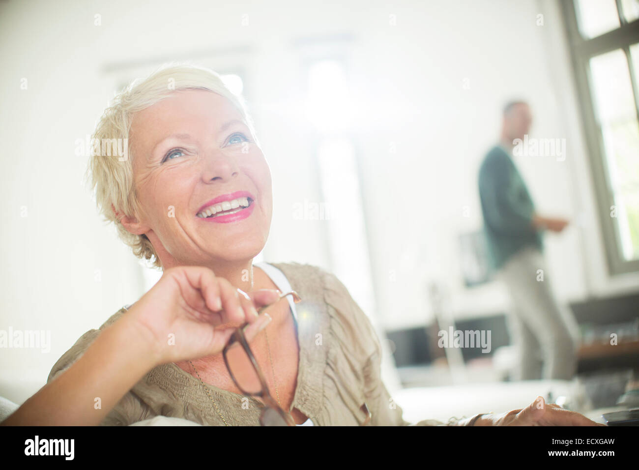 Ältere Frau lächelnd im Innenbereich Stockfoto