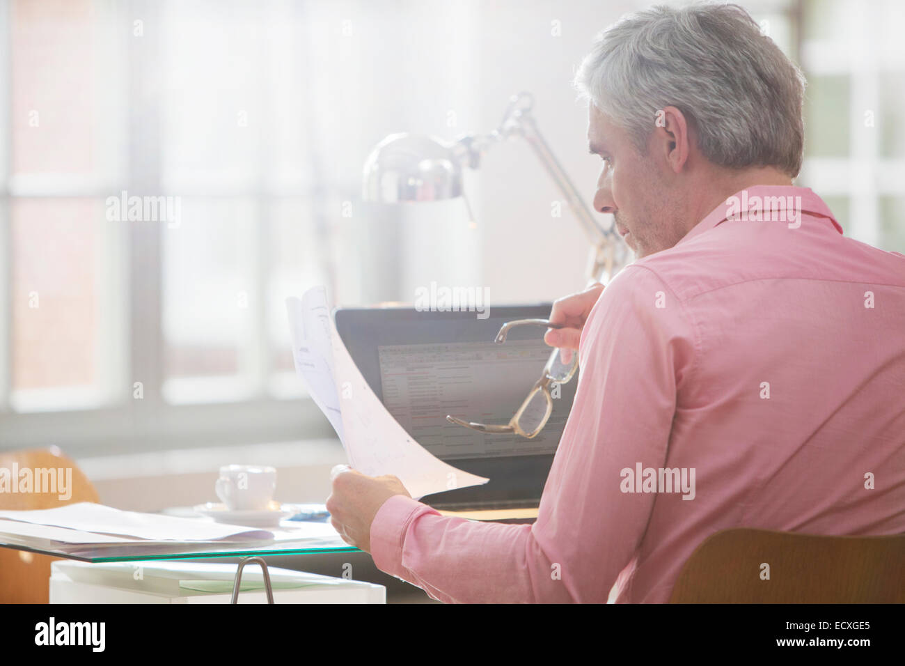 Geschäftsmann lesen Papierkram am Schreibtisch home-office Stockfoto