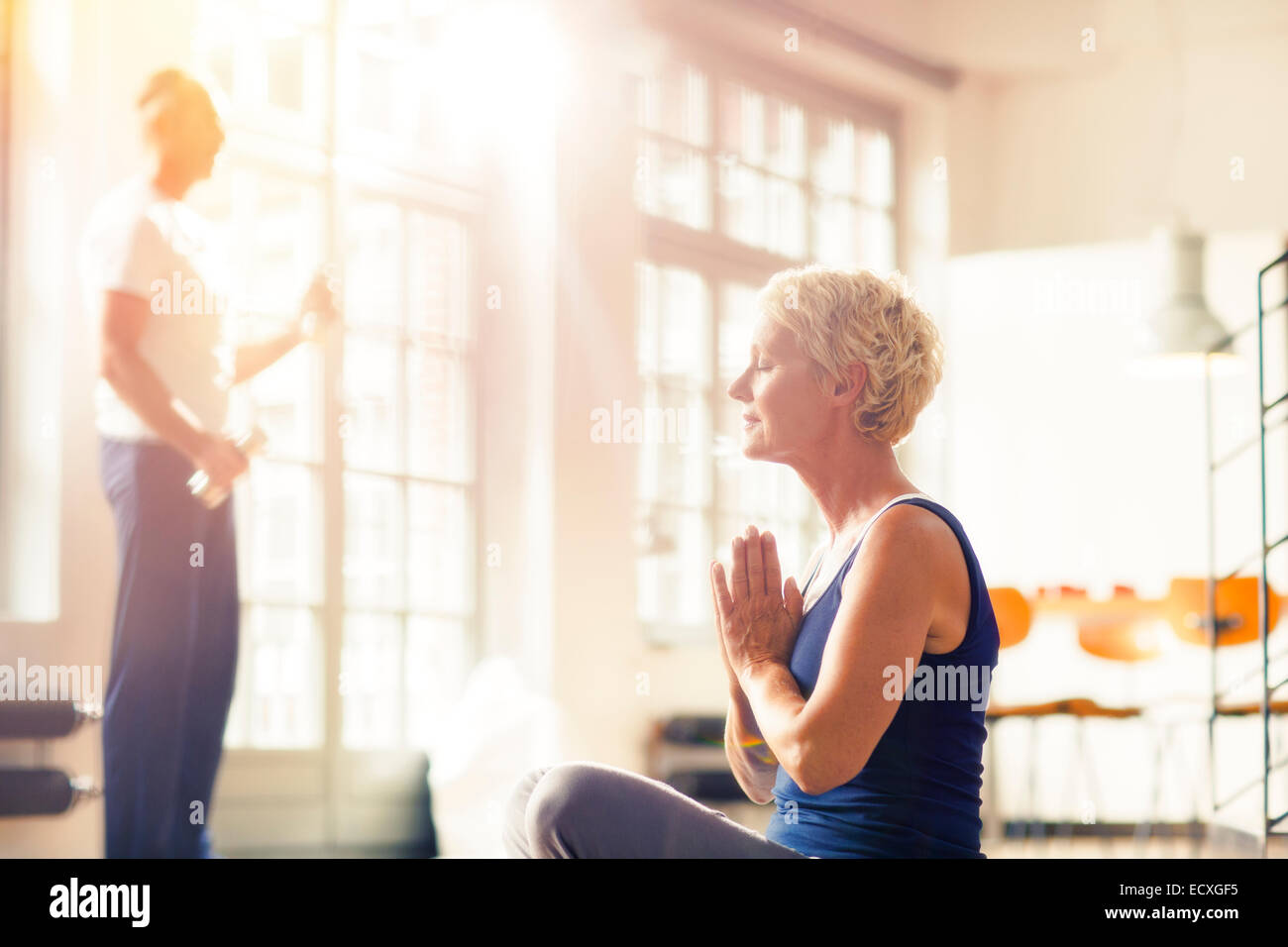 Ältere Frau, meditieren auf Etage Stockfoto