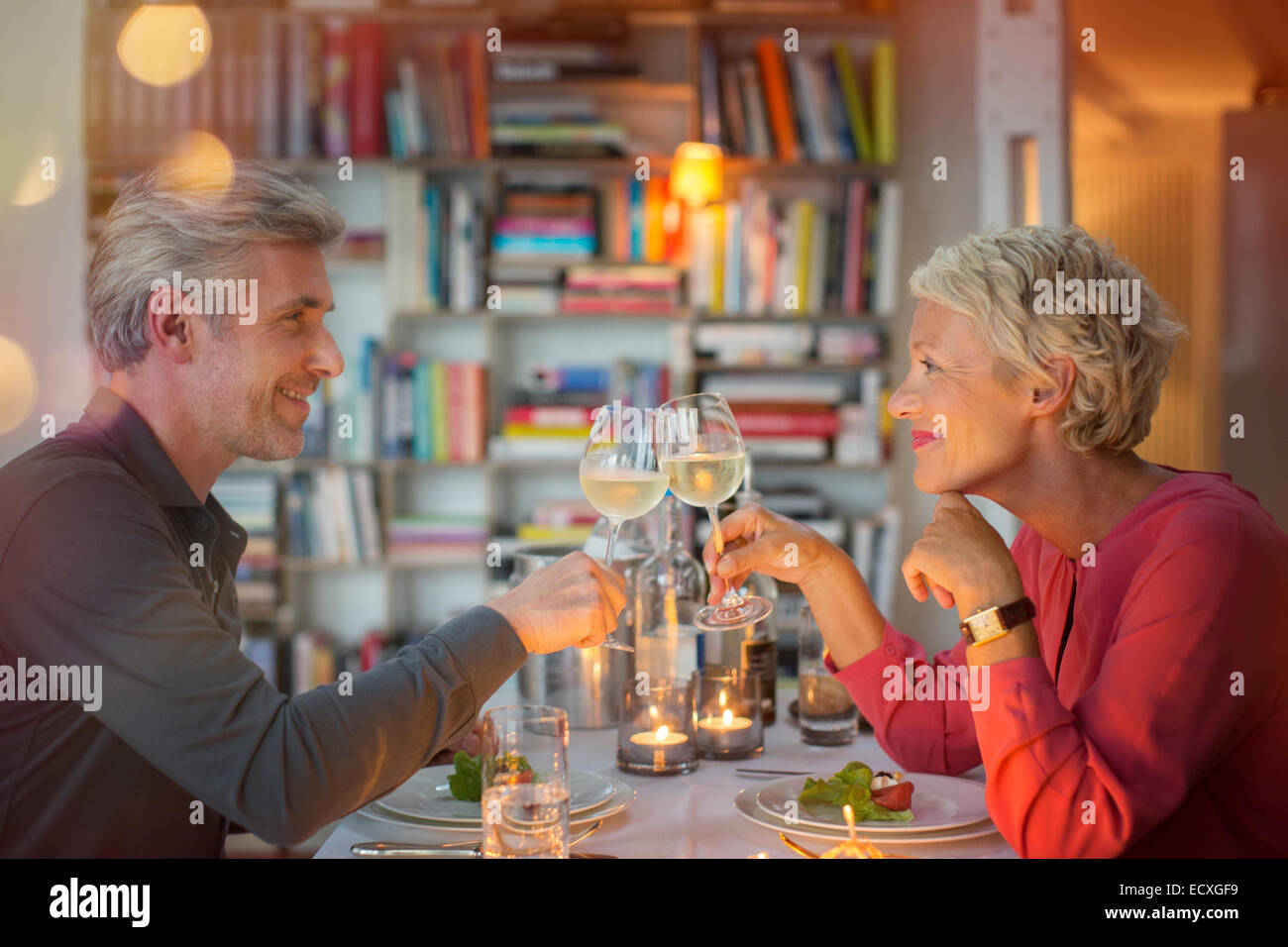 Älteres Ehepaar Toasten einander beim romantischen Abendessen Stockfoto