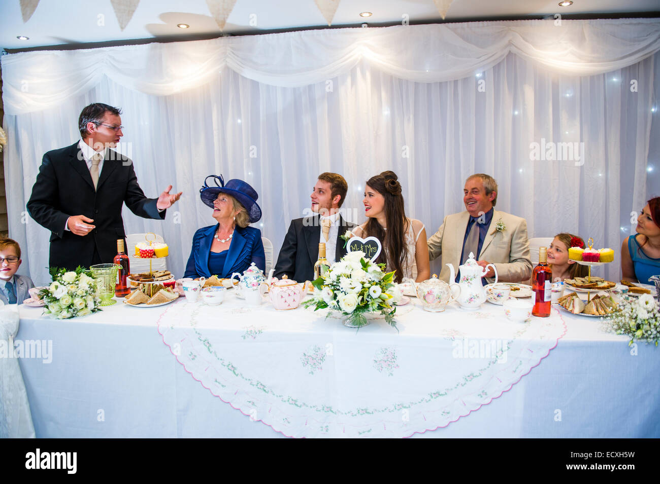 Heiraten / Hochzeit Tag UK: Gäste am Tisch amüsieren sich wie der beste Mann seine Rede auf der Hochzeit Empfang Feier Party nach der Hochzeitsservice gibt Stockfoto
