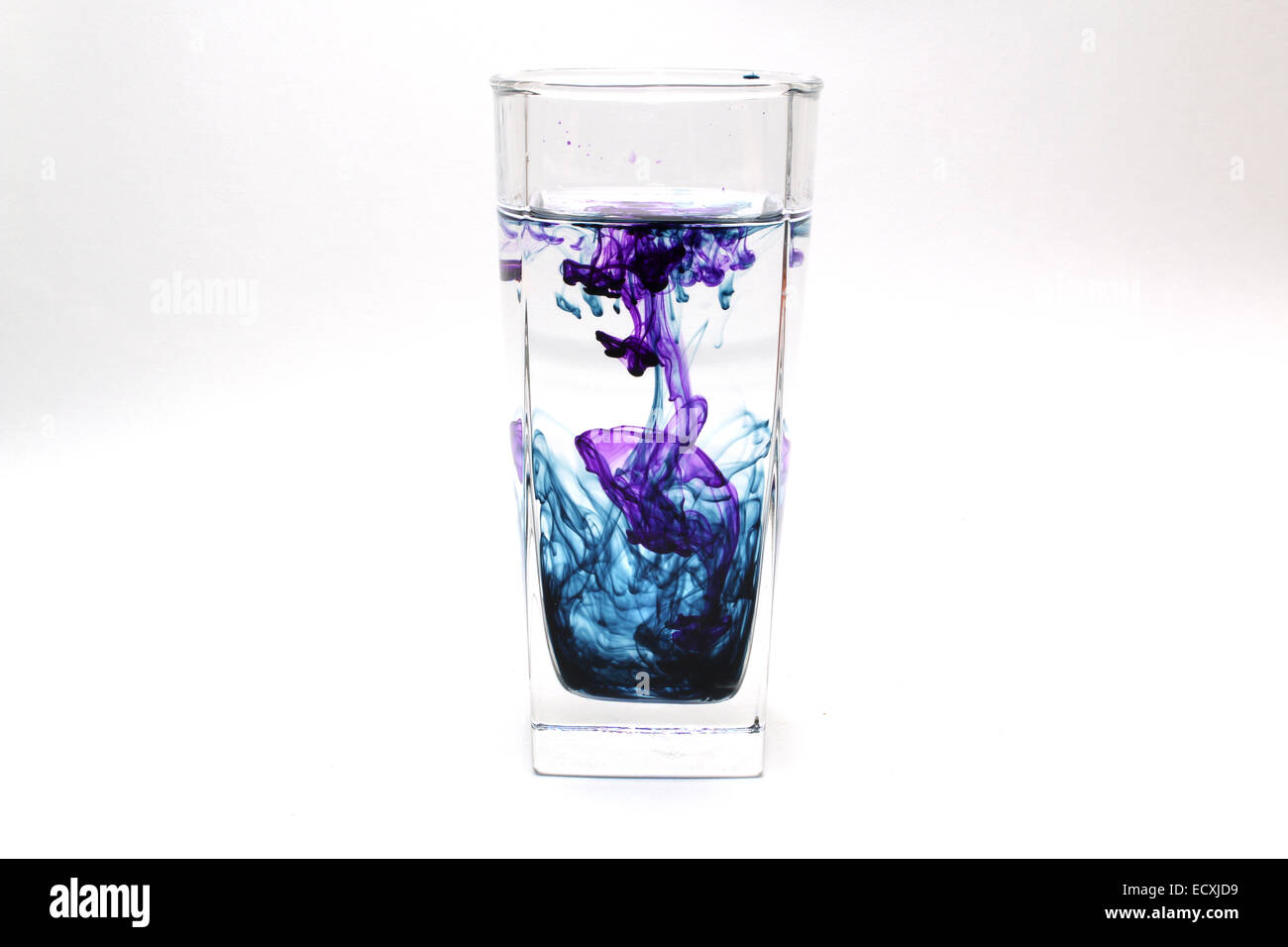 Transparentes Glas mit farbiger Tinte in Wasser Stockfoto