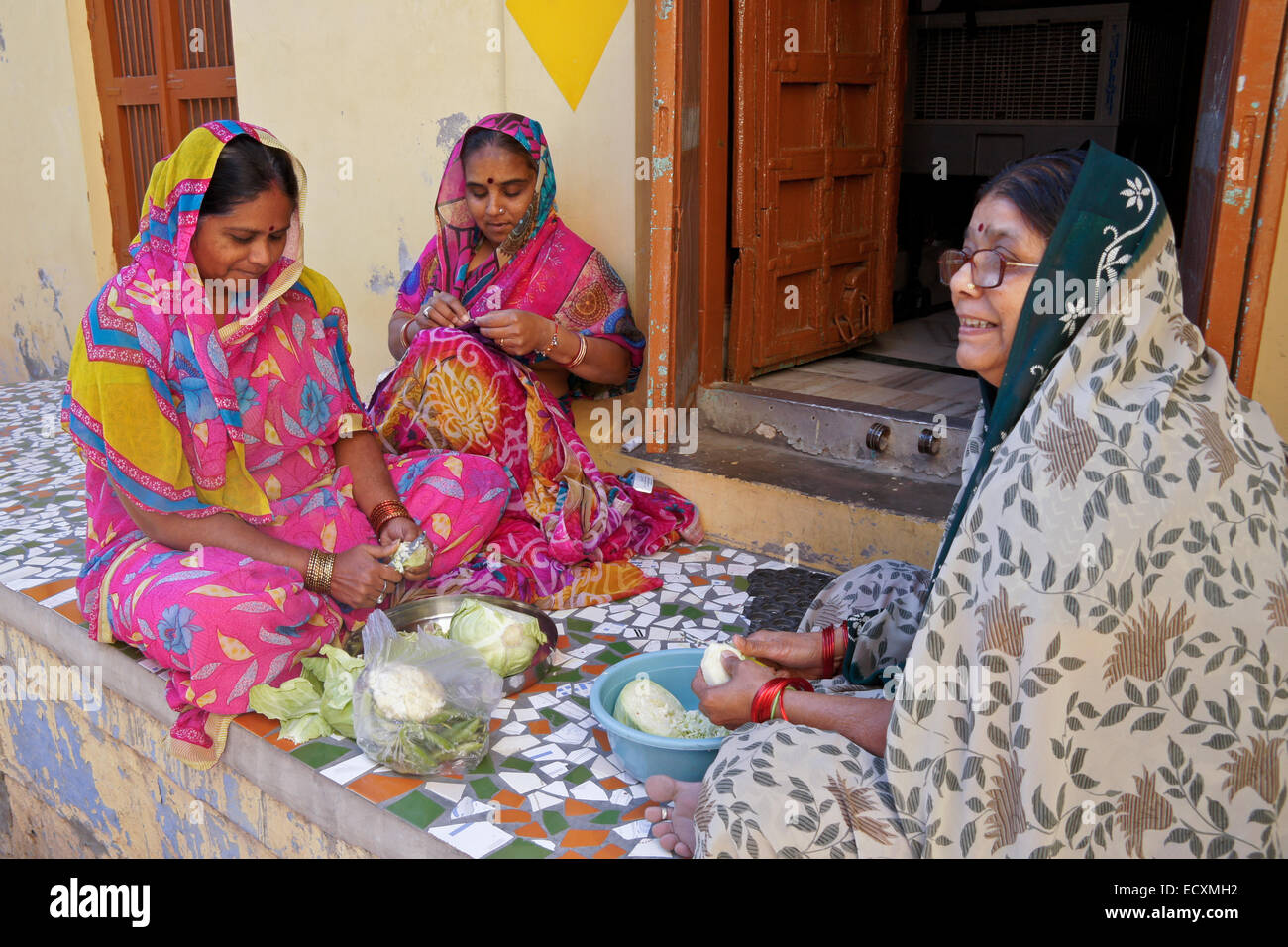 Frauen, die Zubereitung von Speisen vor Haus in die blaue Stadt Jodhpur, Rajasthan, Indien Stockfoto