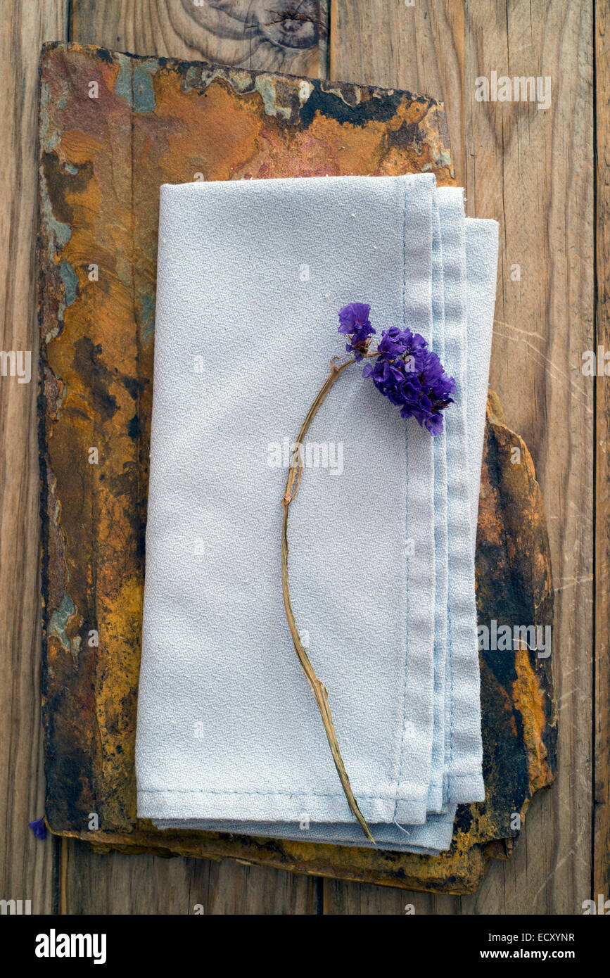 getrocknete Blumen auf blauem Leinen und einer Scheibe aus Quarzit Stockfoto
