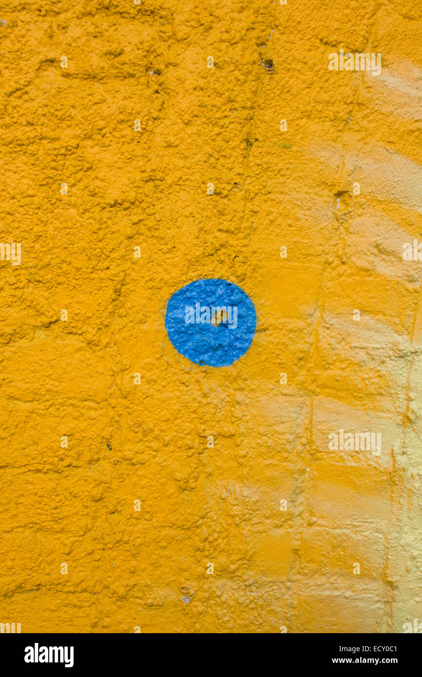 Blauen Fleck auf einer gelben Wand gemalt. Stockfoto
