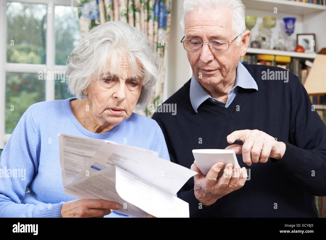 Senior paar zu Hause mit Rechnungen besorgt über persönliche Finanzen Stockfoto