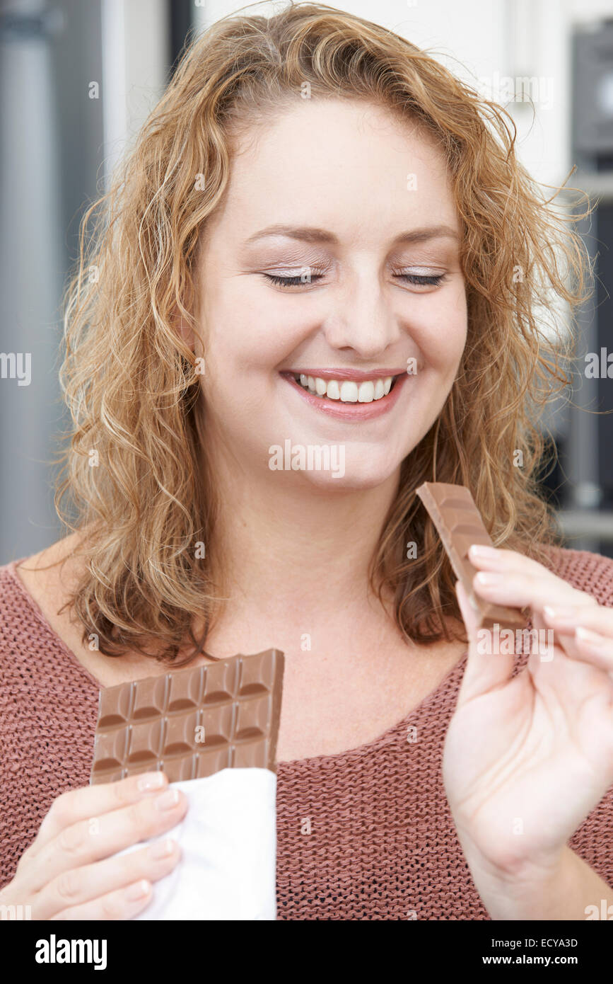 Plus Size Frau genießen Bar Schokolade essen Stockfoto