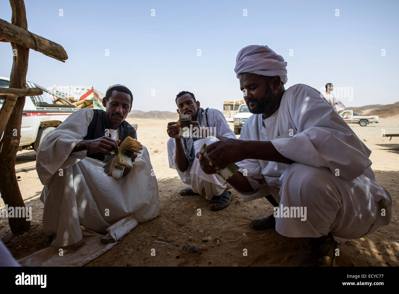 Sudanesische Männer zählen Geld aus dem Verkauf von Faba Bohnen, Sudan Stockfoto