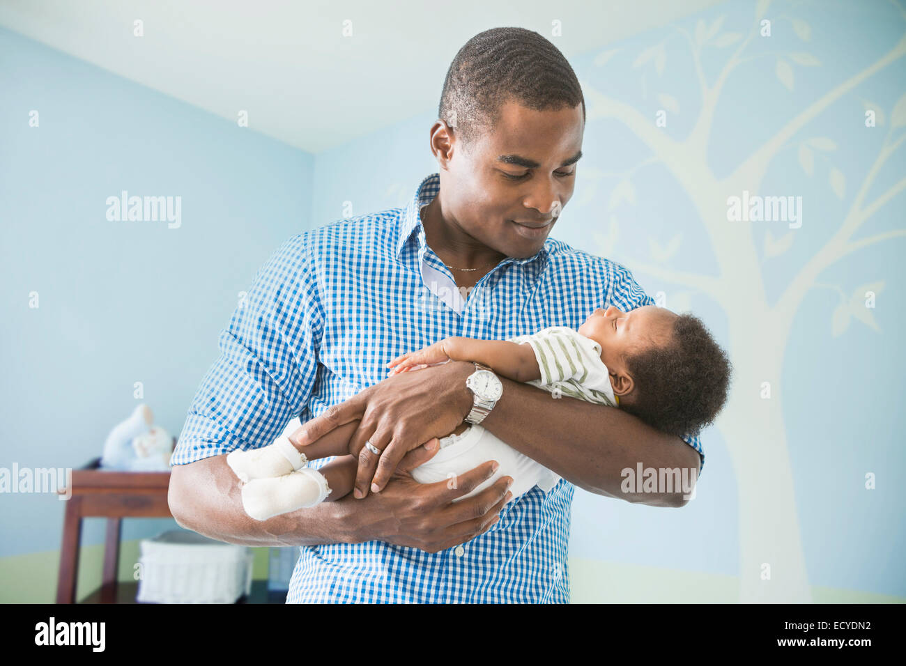 Vater wiegt Baby Sohn Stockfoto