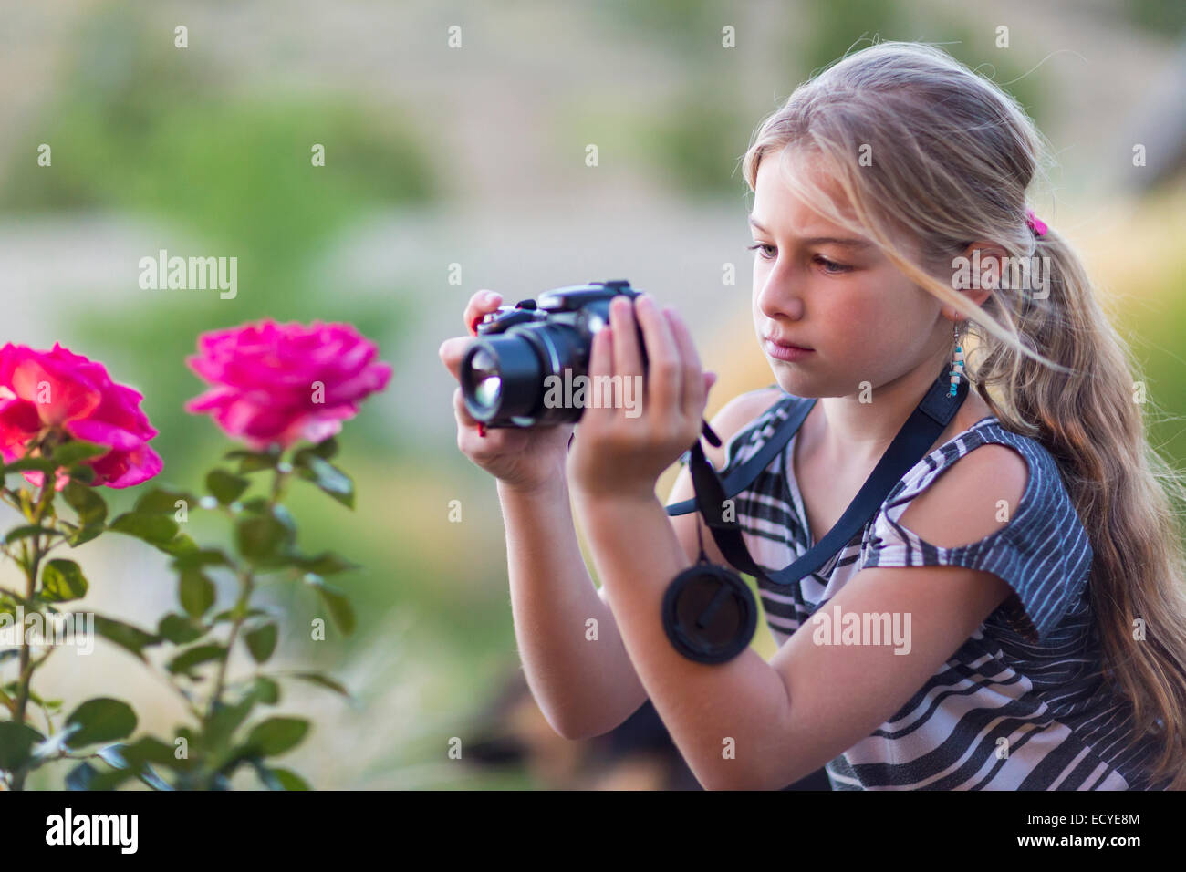 Kaukasische Mädchen fotografieren Blumen im freien Stockfoto