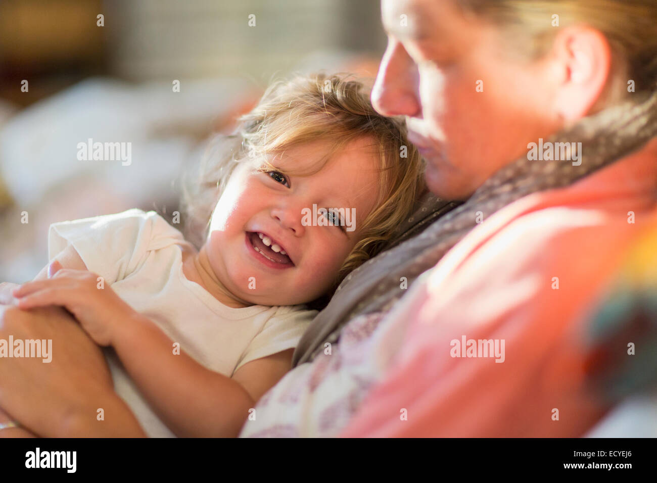 Kaukasische Mutter und Baby Sohn kuscheln auf dem Sofa Stockfoto