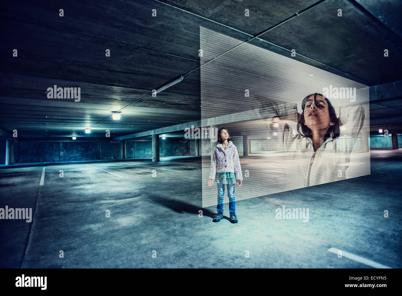 Gemischte Rassen Mädchen beobachten holografischen Bildschirm auf Parkplatz Stockfoto