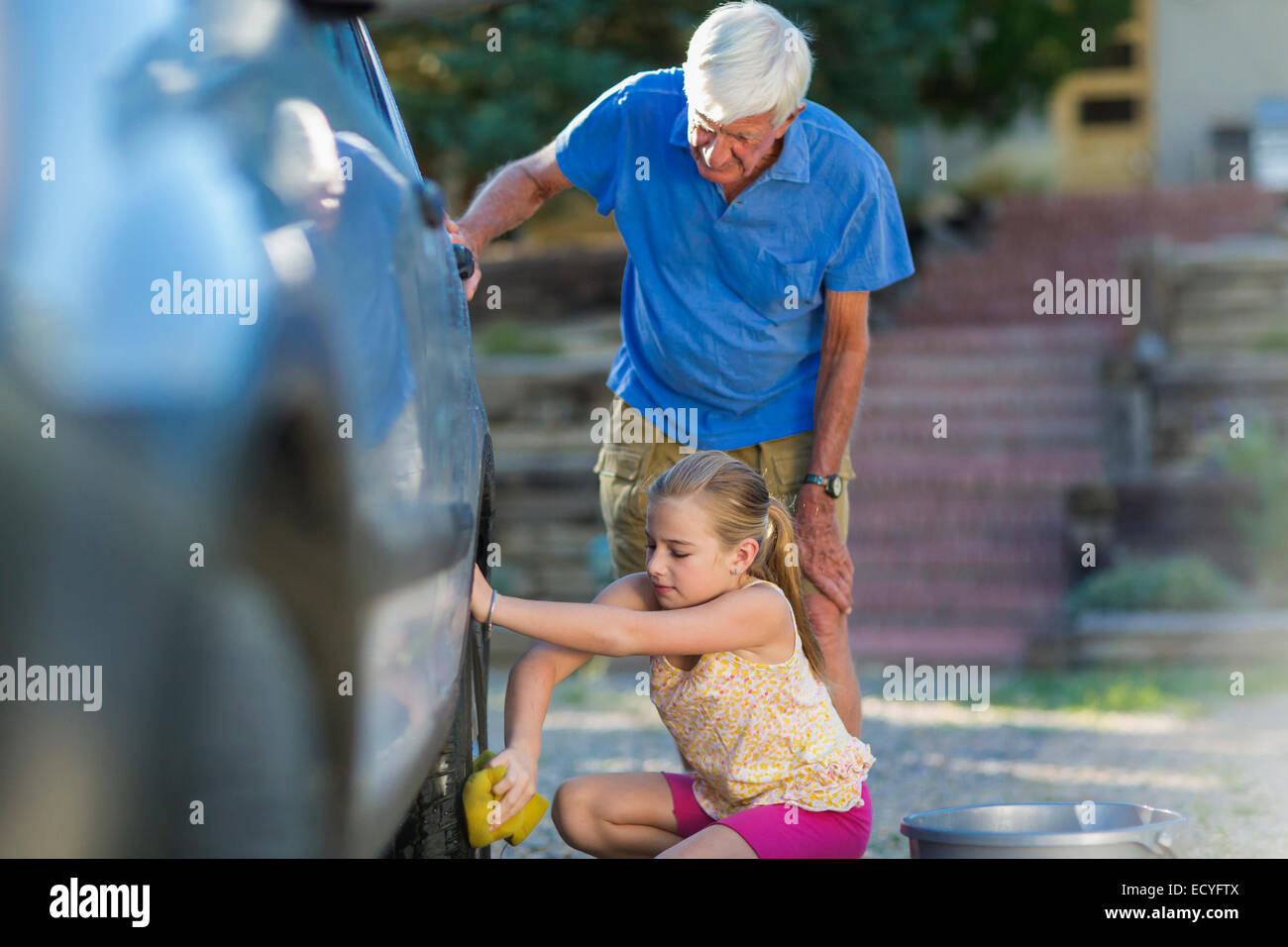 Kaukasische Großvater und Enkelin Waschen Auto im freien Stockfoto