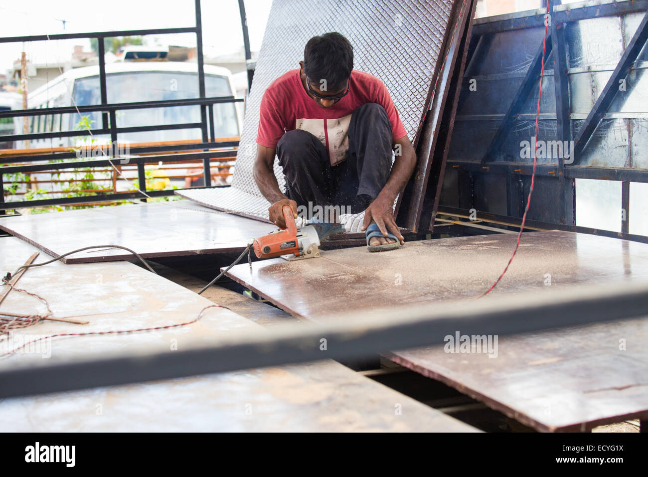 Mann, Sägen auf einen israelischen Bus machen Shop in Kathmandu, Nepal Stockfoto